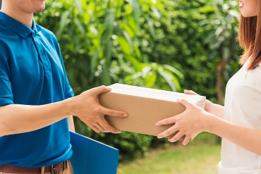 Asian young delivery man courier in uniform hold parcel post boxes