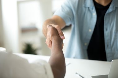 Close up of handshake at office desk