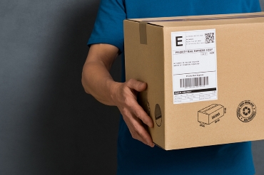 Closeup hands of delivery man holding package to deliver.