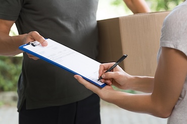 Woman signing receipt of urgent courier delivery package.