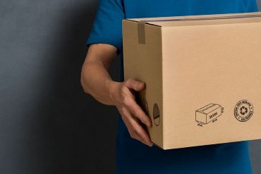 Closeup hands of delivery man holding package to deliver.